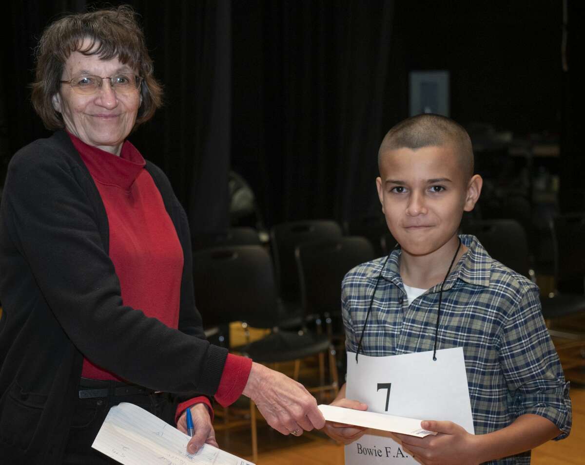 Mary Dearen, Midland Reporter managing editor, awards fourth place to Xavier Carrasco from Bowie Fine Arts Academy 02/23/2019 during the 32nd annual Spelling Bee. Tim Fischer/Reporter-Telegram