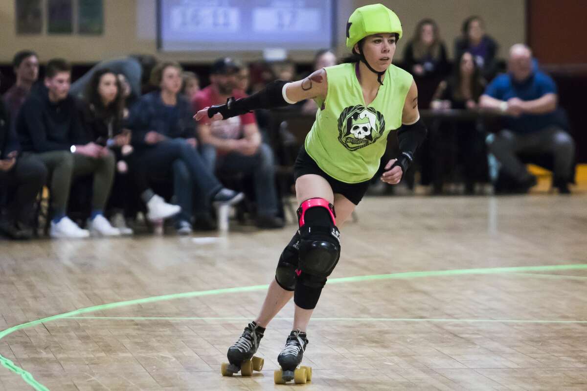 Jessica Bateman, or "Crazy," skates down the track during the Chemical City Derby Girls' annual Mardi Gras Massacre on Saturday, Feb. 23, 2019 at the Roll-Arena in Midland. (Katy Kildee/kkildee@mdn.net)