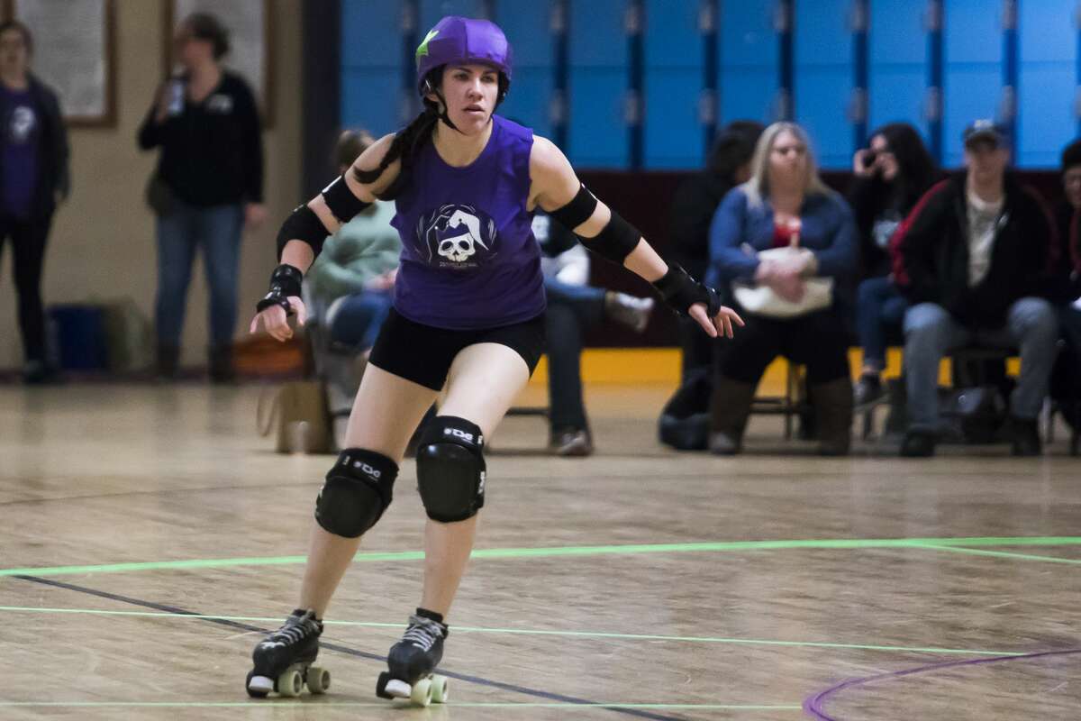 Chris Firlik, or "Velociroller," skates down the track during the Chemical City Derby Girls' annual Mardi Gras Massacre on Saturday, Feb. 23, 2019 at the Roll-Arena in Midland. (Katy Kildee/kkildee@mdn.net)