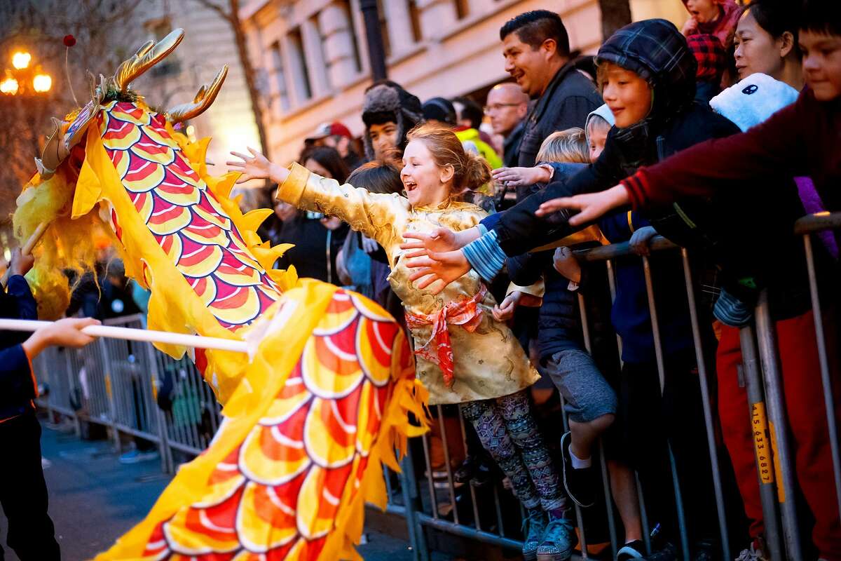 Elisabeth Milich, 7, reaches to touch a dragon during San Francisco's annual Chinese New Year Parade on Saturday, Feb. 23, 2019.