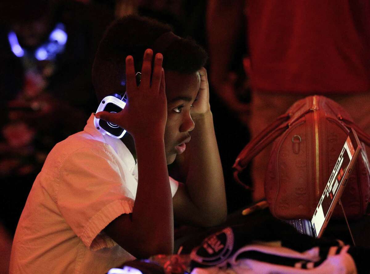 H. Stern, age 10, gestures as he listens to music on glowing headphones during a joint program between Reading With A Rapper (RWAR) and My Brother’s Keeper Houston (MBK) in the Legacy Room at City Hall Sunday, Feb. 24, 2019 in Houston, TX.
