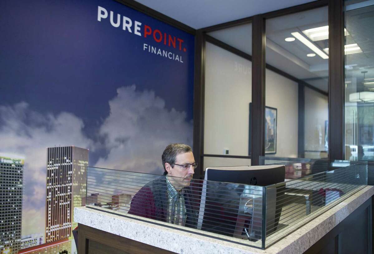 Howard Maple checks his account balance at PurePoint Financial in the Galleria area of Houston. Maple is self-employed and uses PurePoint for his savings account.