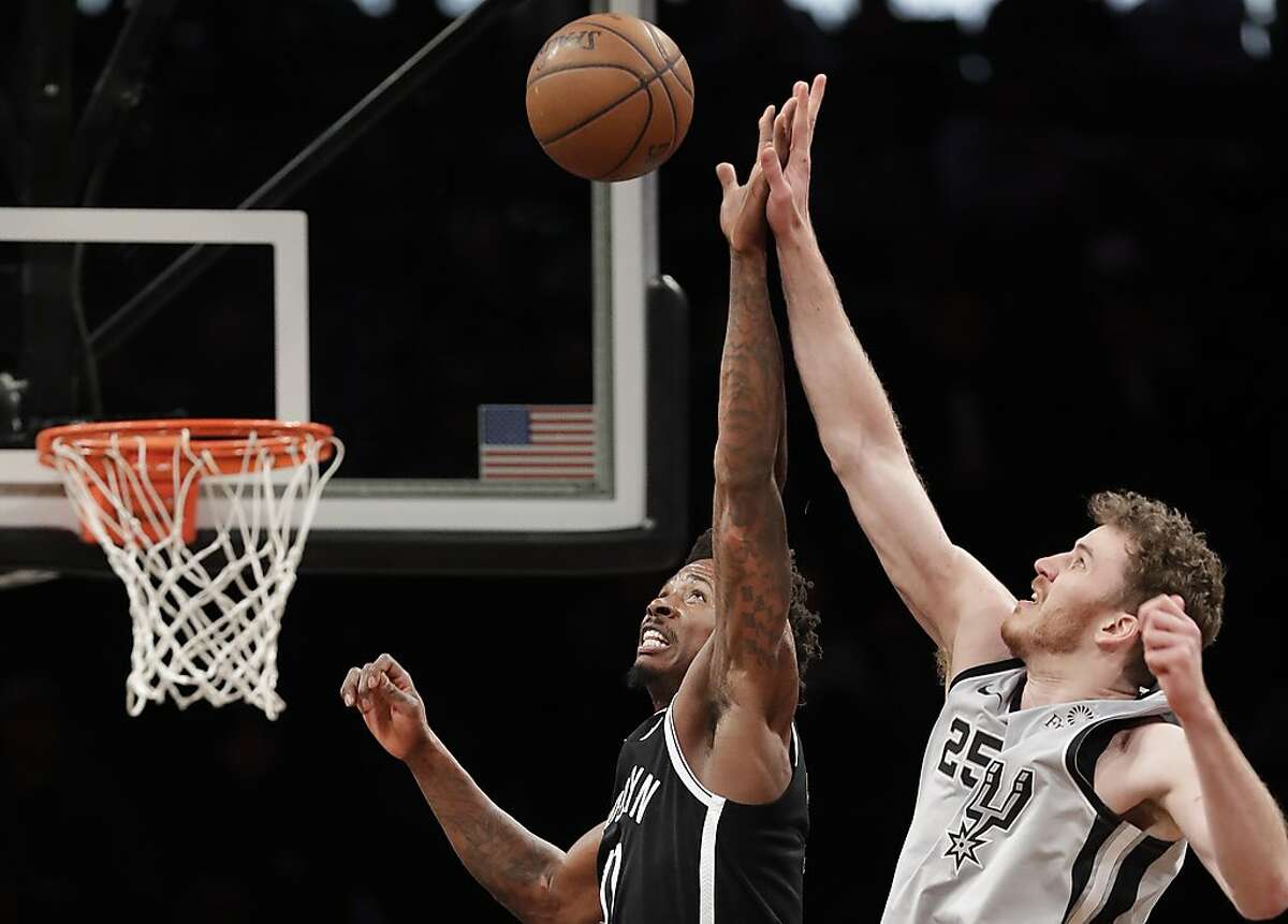 Brooklyn Nets forward Ed Davis, left, tries to tip the ball away from San Antonio Spurs center Jakob Poeltl (25) during the second half of an NBA basketball game, Monday, Feb. 25, 2019, in New York. (AP Photo/Kathy Willens)