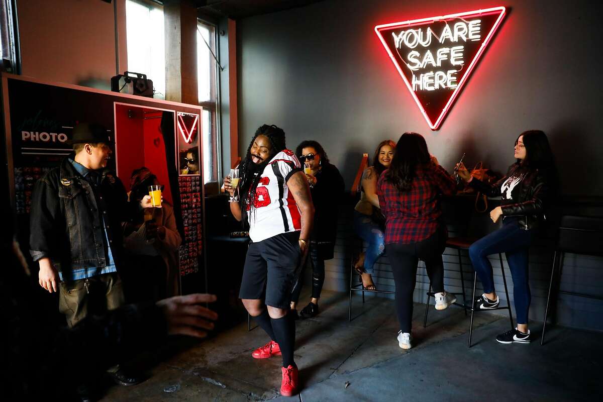 People hang out under the "You are safe here" sign at Jolene's bar in San Francisco, California, on Sunday, Feb. 17, 2019.