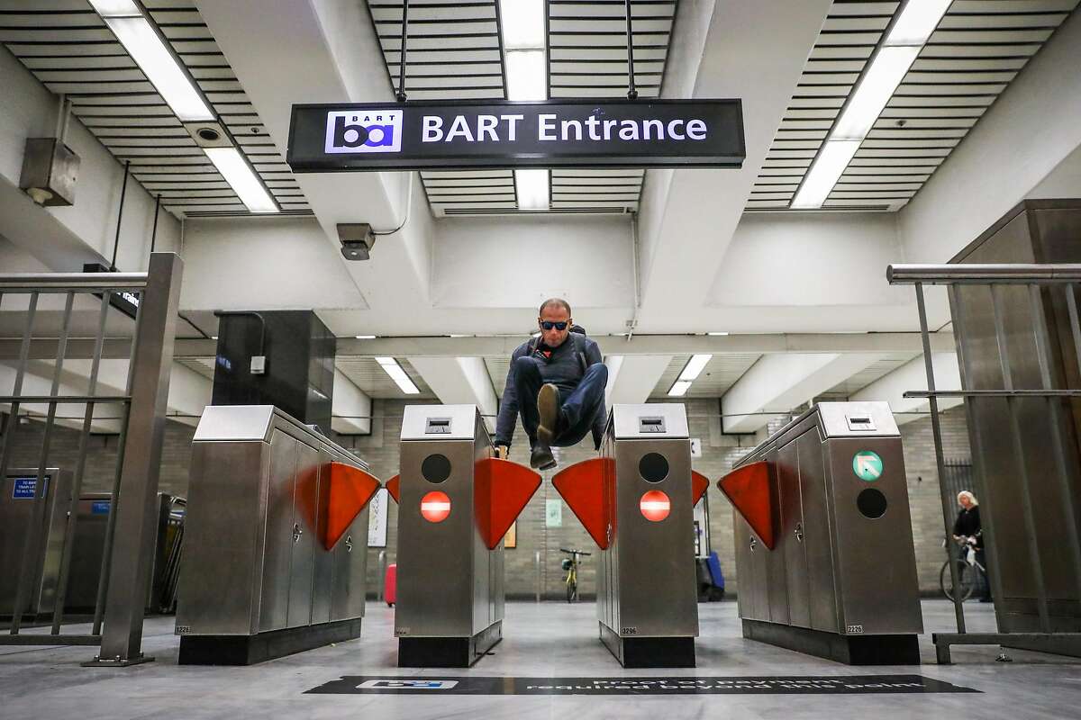 A man jumps the turnstile at the BART station at Civic Center despite gates that were installed (seen at left and right) to deter fare evasion in San Francisco, California, on Thursday, Aug. 16, 2018.