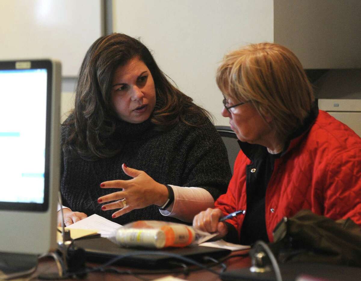 Greenwich Commission on Aging Director Lori Contadino, left, assists a Greenwich resident with Medicare paperwork at the Senior Center in Greenwich, Conn. Monday, Nov. 27, 2017.