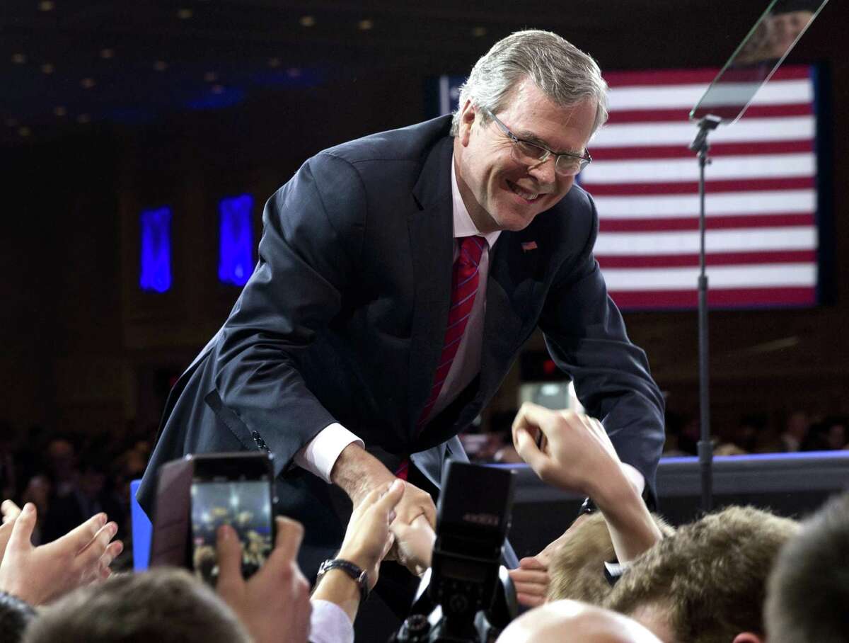 In this file photo from Feb. 27, 2015, former Florida Gov. Jeb Bush shakes hands with people in the audience after speaking at the Conservative Political Action Conference (CPAC) in National Harbor, Md.