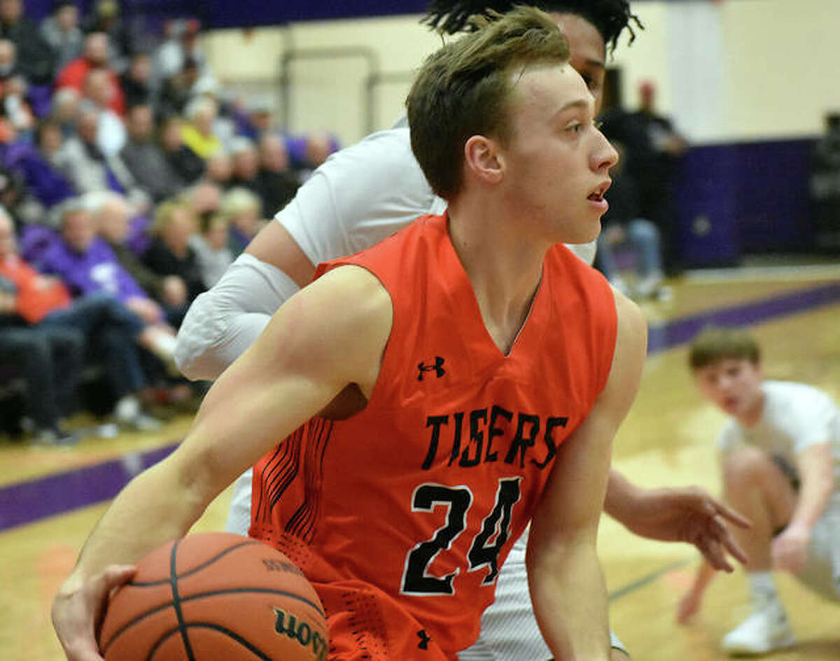 Edwardsville’s A.J. Robertson drives baseline and looks for an open teammate during the second quarter against Collinsville.