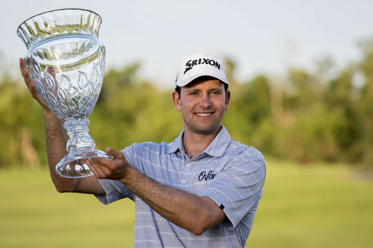 Martin Trainer of California holds the championship cup after winning the Puerto Rico Open PGA golf tournament in Rio Grande, Puerto Rico, Sunday, Feb. 24, 2019. (AP Photo/Carlos Giusti)