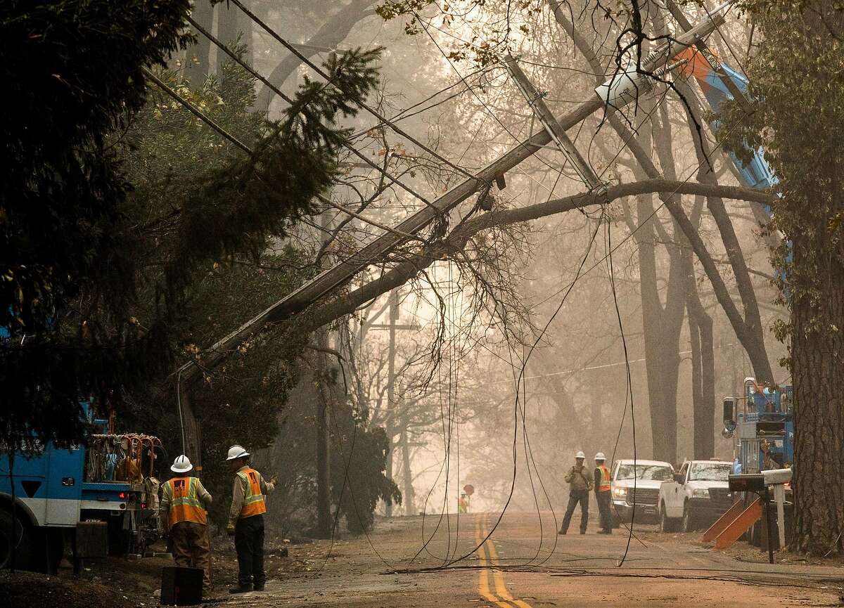 PG&E work to take down a downed telephone pole after the Camp Fire devastated the entire town of Paradise, Calif. Saturday, Nov. 10, 2018.