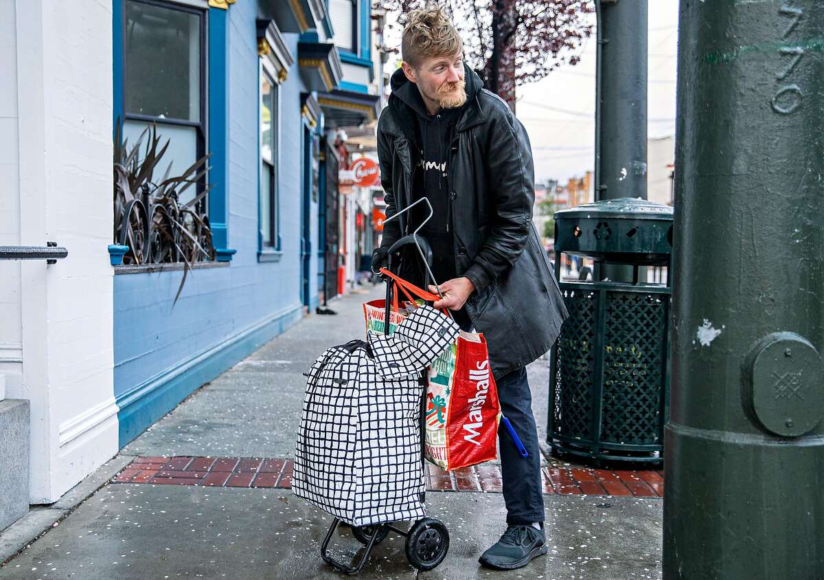 John Constantine, 39, cleans up his area after sleeping in a storefront near 14th Street along Market Street in San Francisco, Calif. Wednesday, Feb. 27, 2019.
