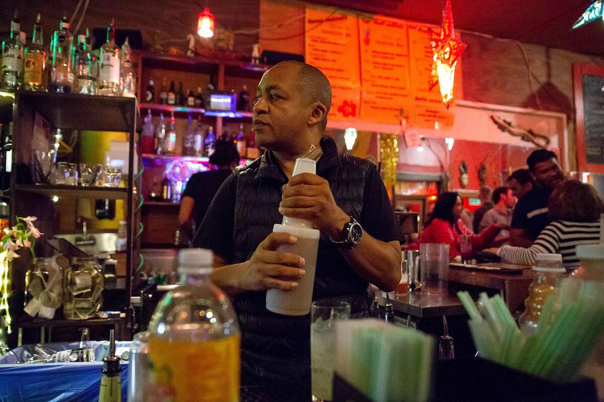 2018年9月28日，星期五，在加州旧金山，Bissap Baobab的老板Marco Senghor在他的餐厅里为顾客调制饮料。