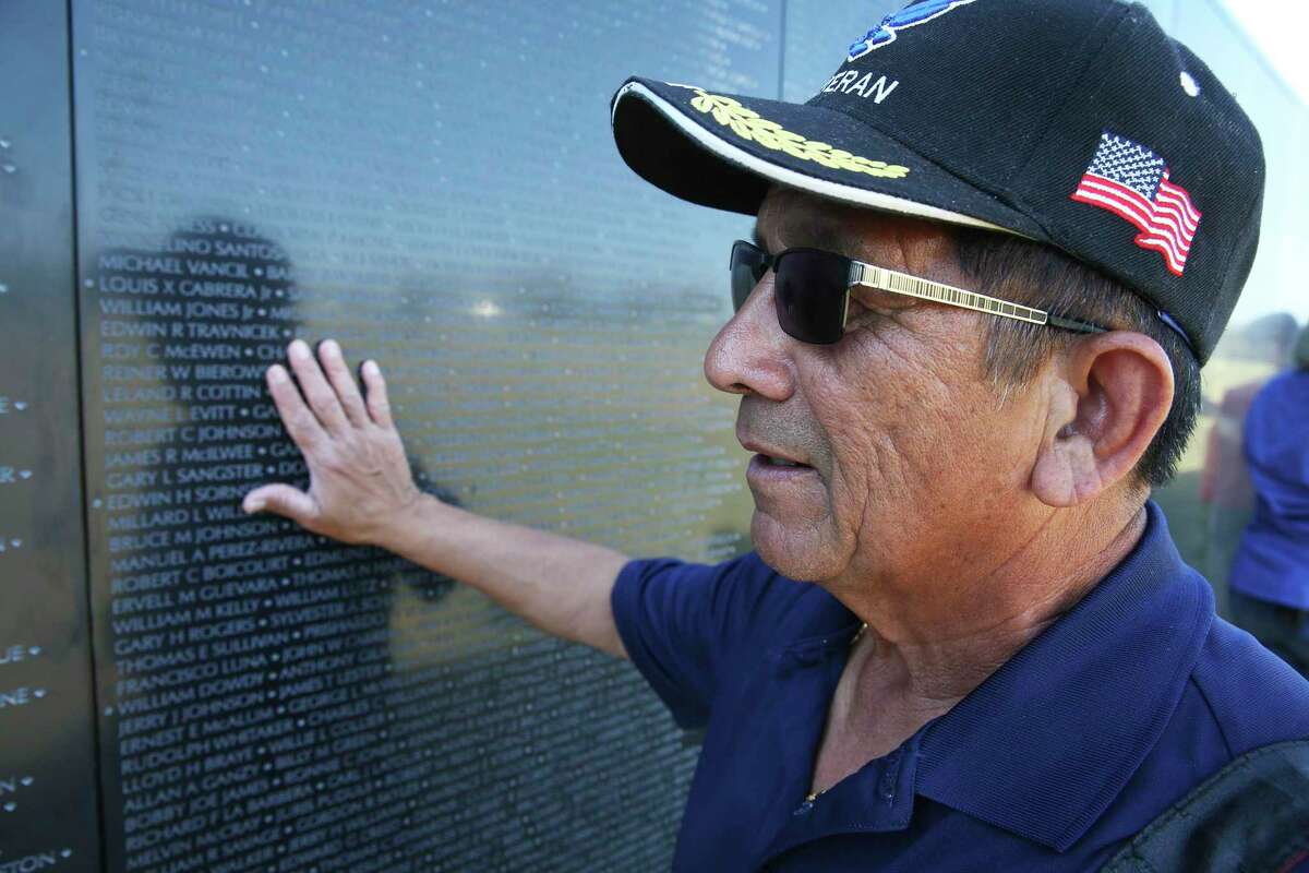 Vietnam veteran Martin Cavazos immediately becomes emotional as he touches “The Wall That Heals,” a traveling Vietnam Memorial Wall replica assembled at Fort Sam Houston National Cemetery last February. Cavazos was a combat photographer in the war. A series of Veterans Day events are planned this weekend and Monday in the area.
