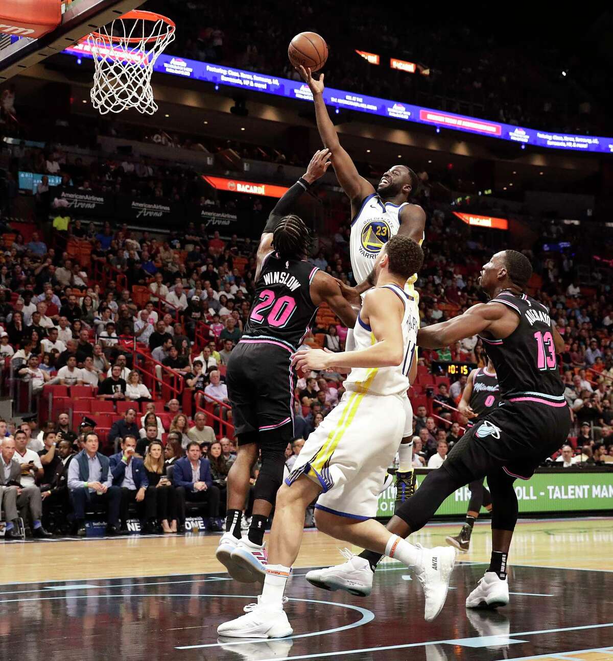 Golden State Warriors forward Draymond Green (23) shoots the ball against Miami Heat forward Justise Winslow (20) during the first half of an NBA basketball game Wednesday, Feb. 27, 2019, in Miami.