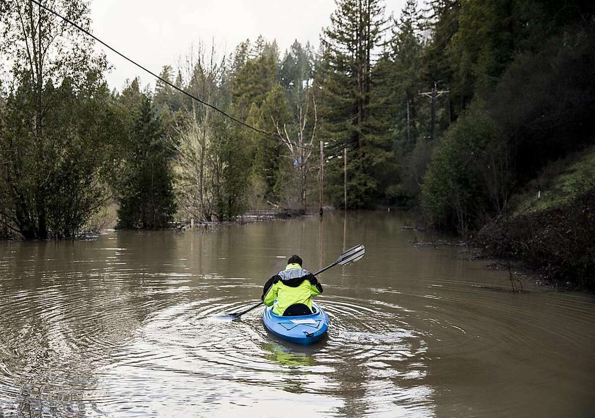 Guerneville resident Jeremiah Fox, 43, paddles out on a kayak as he attempts to navigate through high flood waters to check on his property along Highway 116 in Guerneville, Calif. Thursday, Feb. 28, 2019.