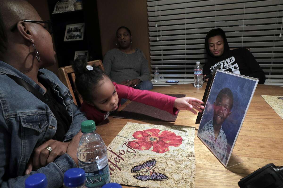 Peyton McCoy, 3, reaches for a photo of her uncle Willie McCoy, at the home of Kori McCoy in Hercules, Calif., on Thursday, February 14, 2019. The family of Willie McCoy, who was shot and killed by Vallejo Police officers as he woke up from sleeping in his car at a Taco Bell restaurant, gathered for press conference to address their issues with how their loved one was killed.