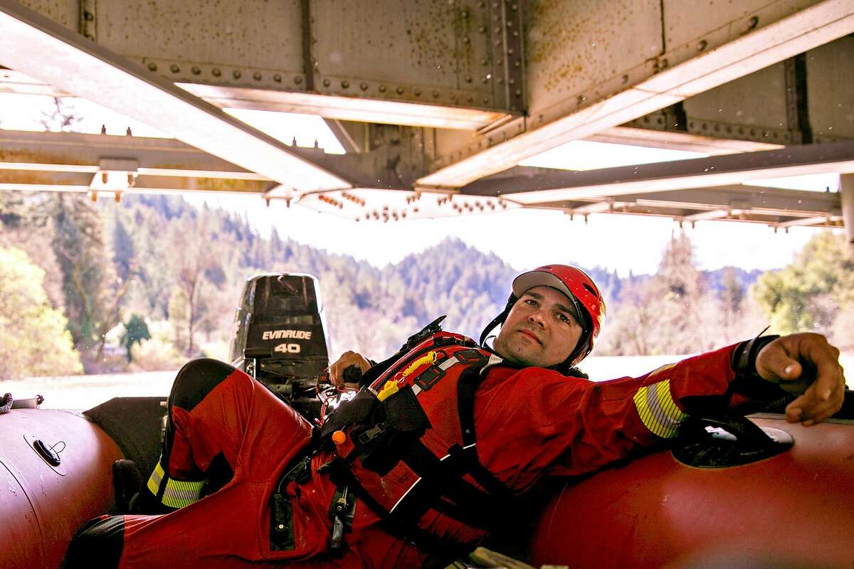 Forestville Fire Department Engineer Chuck Franceschi ducks under the River Road Bridge as he drives a rescue boat through the flooded Russian River to patrol communities affected in Forestville, Calif. Thursday, Feb. 28, 2019.