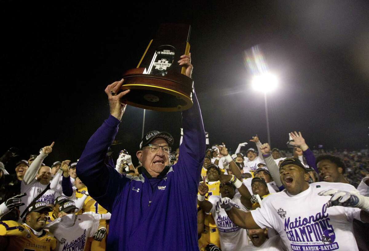 Mary Hardin-Baylor head coach Pete Fredenburg holds up the NCAA Division III college football championship trophy after defeating Mount Union 24-16 to win the Stagg Bowl at Woodforest Bank Stadium, Friday, Dec. 14, 2018, in Shenandoah.