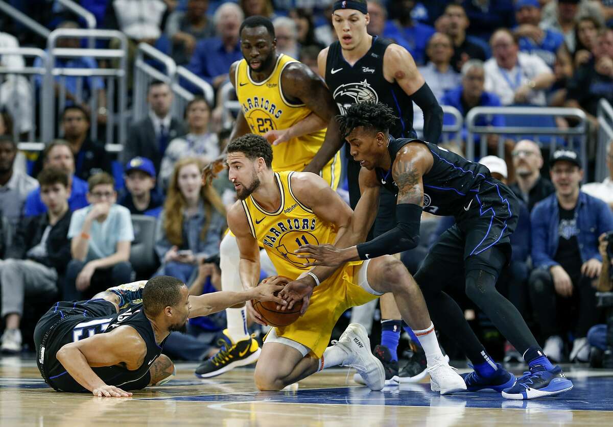 Orlando Magic guard Isaiah Briscoe (13) and forward Wesley Iwundu (25) fight for the loose ball with Golden State Warriors guard Klay Thompson (11) as Magic forward Aaron Gordon (00) and Warriors forward Draymond Green (23) look on during the second half of an NBA basketball game in Orlando, Fla., on Thursday, Feb. 28, 2019. (AP Photo/Reinhold Matay)