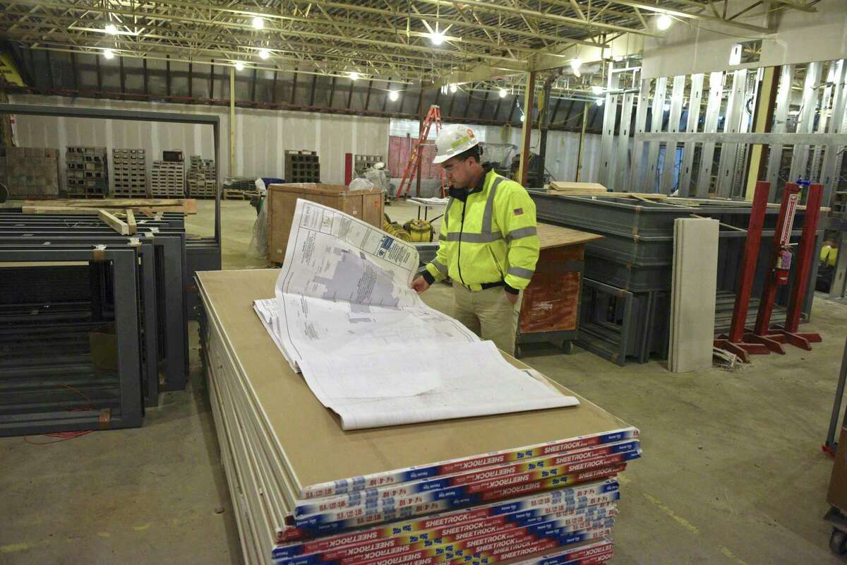 Tim Chan, project manager with O&G Industries, looks at plans for the new agriscience academy at Shepaug Valley School in the new multi-purpose room. Washington, Conn. Wednesday, February 27, 2019.