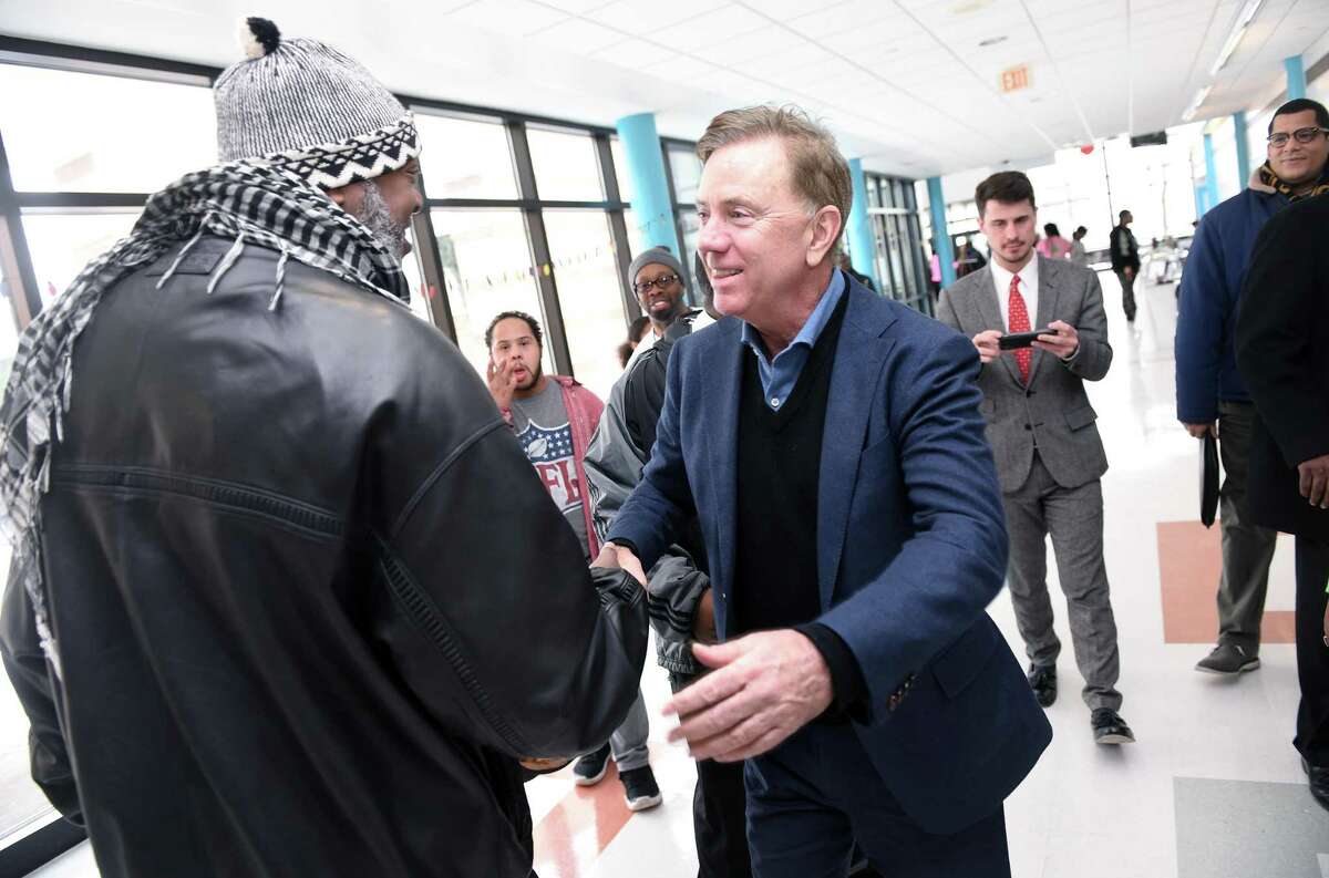 Maurice Williams of New Haven (left) greets Governor Ned Lamont (center) at the annual Dr. Martin Luther King, Jr. Conference at Wexler-Grant Community School in New Haven on January 21, 2019.