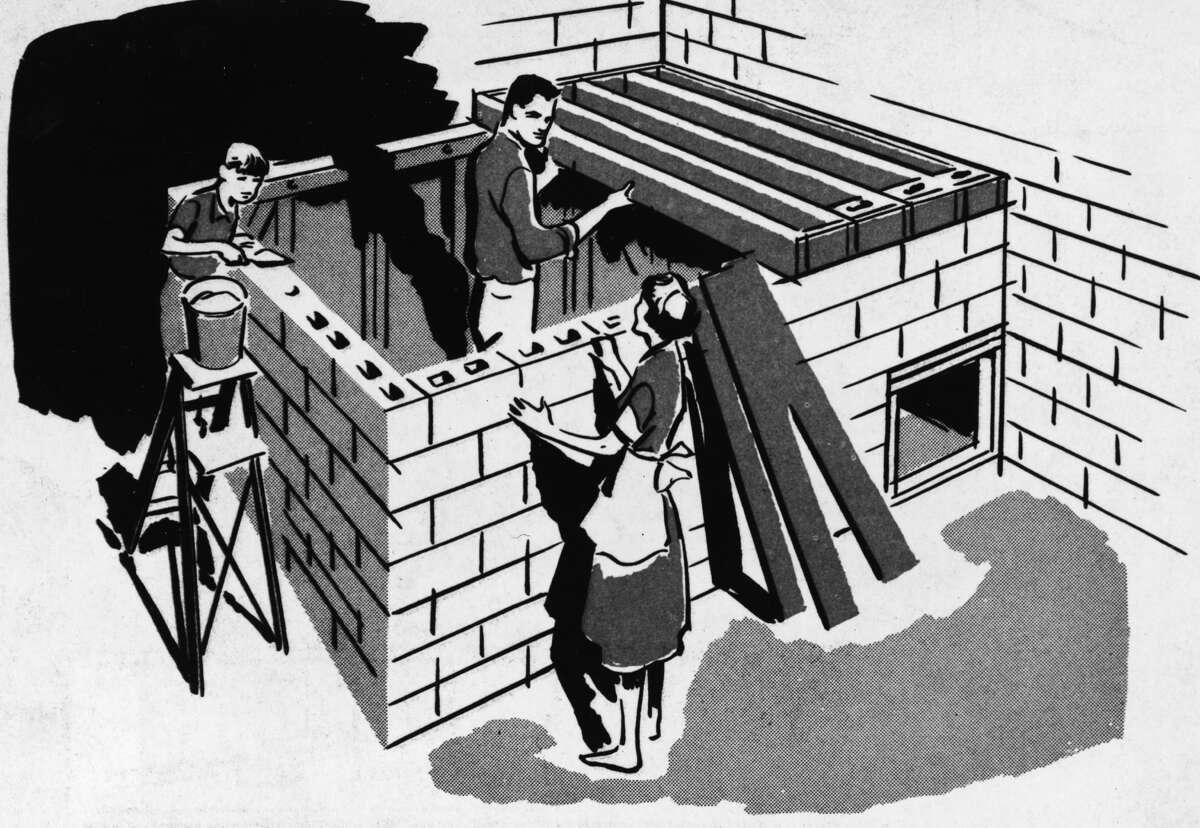 Illustration of a family building a bomb fallout shelter together, using sand-filled concrete blocks for roof shielding, from a U.S. Department of Defense publication, 1961.
