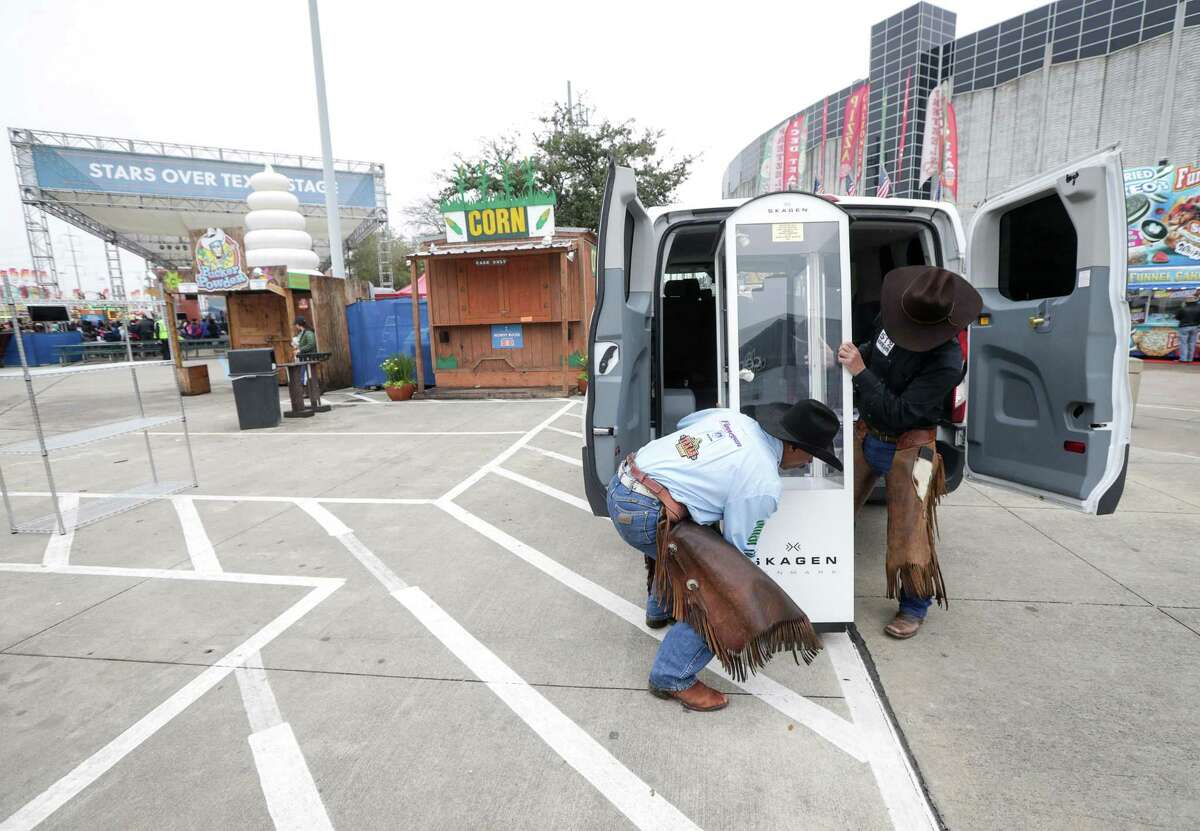 Larry Callies, left, and Edmund Samora, both co-founders of the Black Cowboy Museum in Rosenberg, Texas, load a display into their van on Black Heritiage Day at the Houston Livestock Show and Rodeo Friday, March 1, 2019, in Houston.