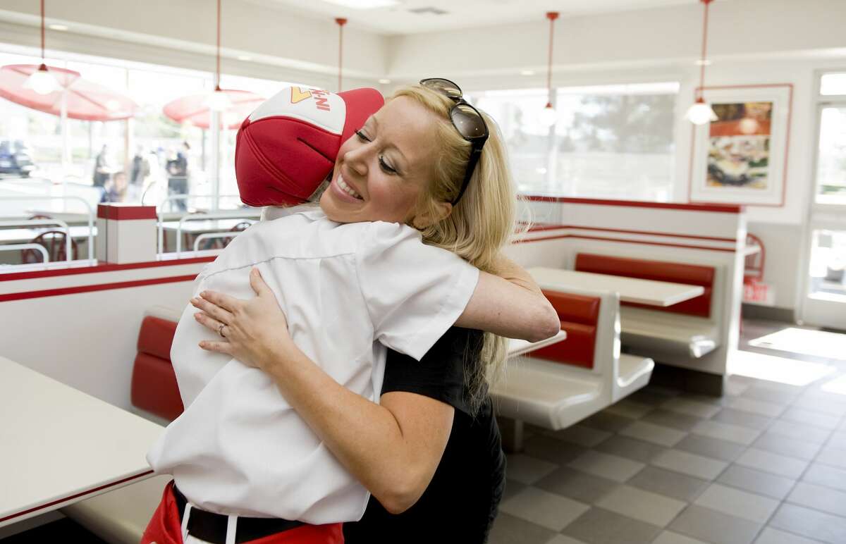 In-N-Out Burger CEO Lynsi Snyder, right, gives 18-year employee Barbie Fowler, 70, a hug at the grand opening of the new Rancho Santa Margarita restaurant in 2013.