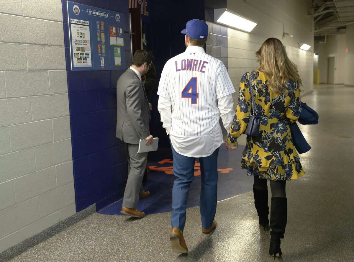 A member of the New York Mets staff shows newly signed New York Mets infielder Jed Lowrie (4) and his wife Milessa to the clubhouse before a photo session on the field at CitiField following a press conference introducing Lowrie to the media, Wednesday, Jan. 16, 2019, in New York.