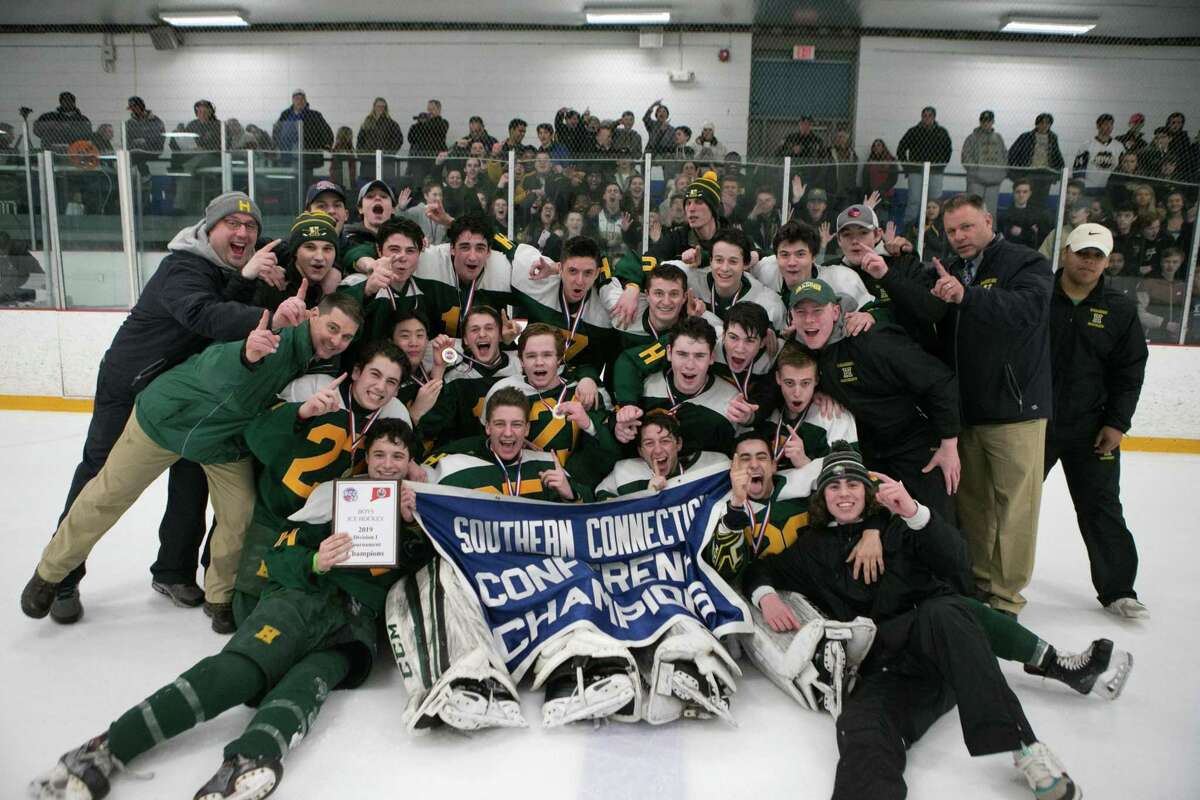 Members of the Hamden boys hockey team celebrate after winning the SCC Division I championship on Friday.