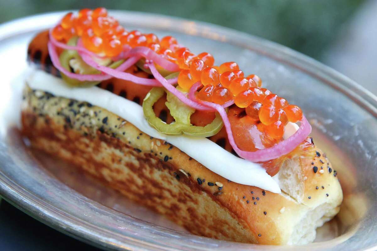 Deep Dive's $18 hot dog features a hazelnut smoked, grass-fed, all-beef hot dog, whipped cream cheese, pickled jalapeños, pickled red onions and pink salmon caviar all in a Ben's Bread seeded bun at made fresh in-house.