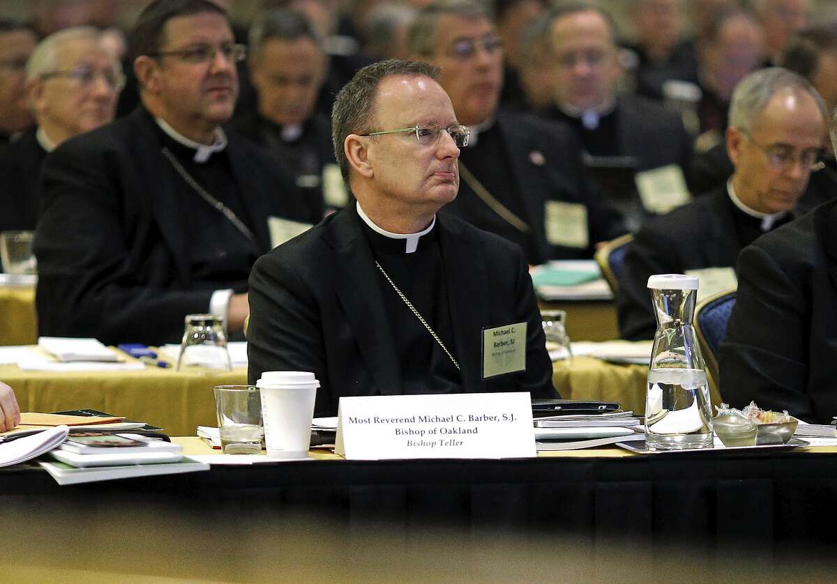 FILE - In this Nov. 12, 2013, file photo, Roman Catholic Diocese of Oakland Bishop Michael Barber, center, listens to a presentation alongside fellow bishops at the United States Conference of Catholic Bishops' annual fall meeting in Baltimore. The Catholic Diocese of Oakland, Calif., has released the names of 45 priests, deacons and religious brothers who officials say are "credibly accused" of sexually abusing minors. The San Francisco Chronicle says Monday that Oakland's list goes back to 1962, when the diocese was founded. None of the men are currently in the ministry. Of the 45 people named, 20 were priests. (AP Photo/Patrick Semansky, File)