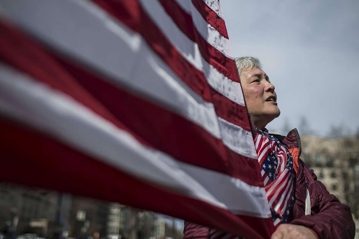 WASHINGTON, DC - FEBRUARY 18: A demonstrator holds an American flag in Lafayette Square during a demonstration organized by the American Civil Liberties Union (ACLU) protesting President Donald Trump's declaration of emergency powers on February 18, 2019 in Washington, DC. (Photo by Zach Gibson/Getty Images)