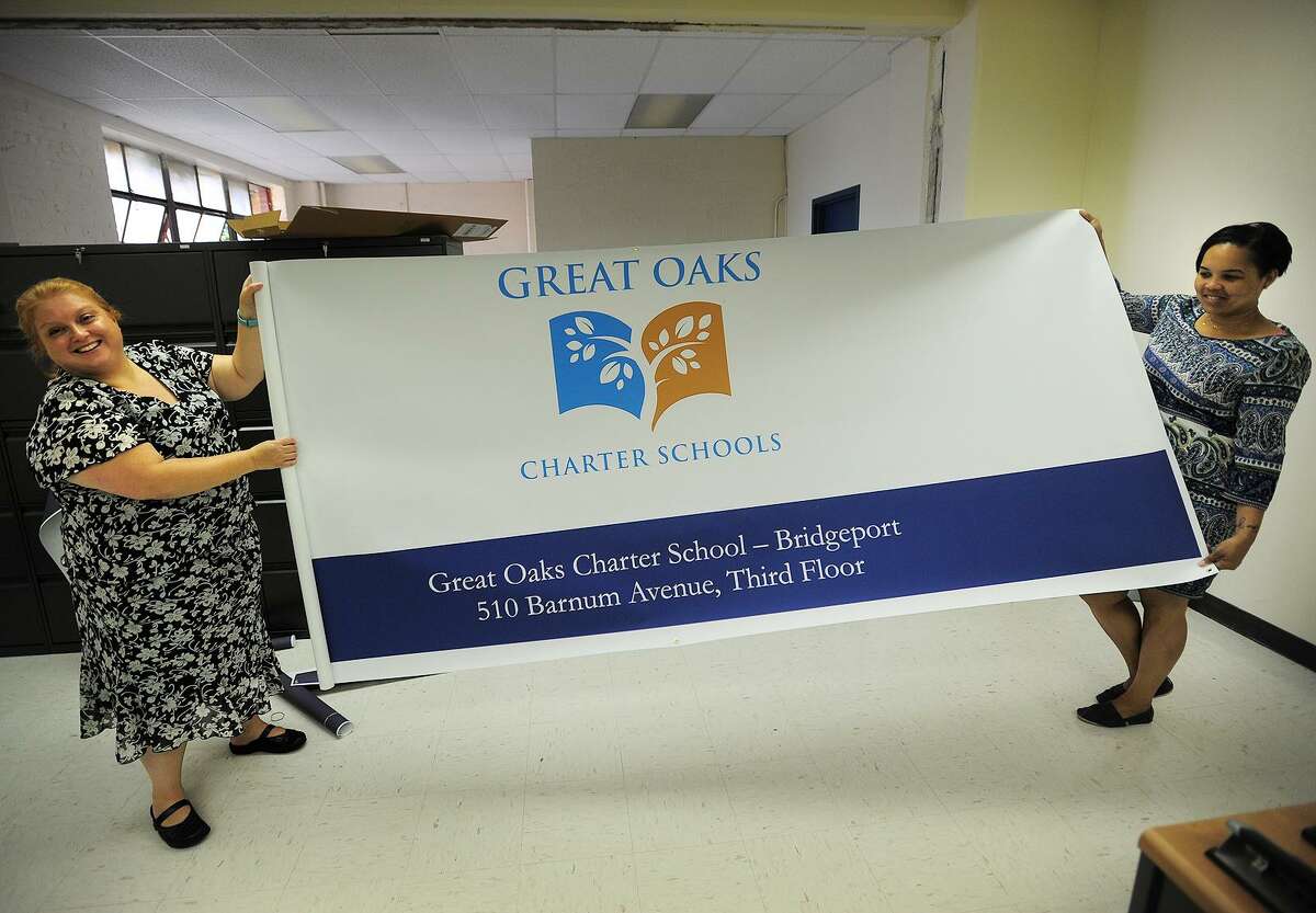 Then executive director/principal Monica Maccera Filppu, left and Superintendent of Great Oaks Foundation Christina Grant unveil the banner for the new Great Oaks Charter School at 510 Barnum Avenue in Bridgeport, Conn. on Thursday, August 21, 2014.