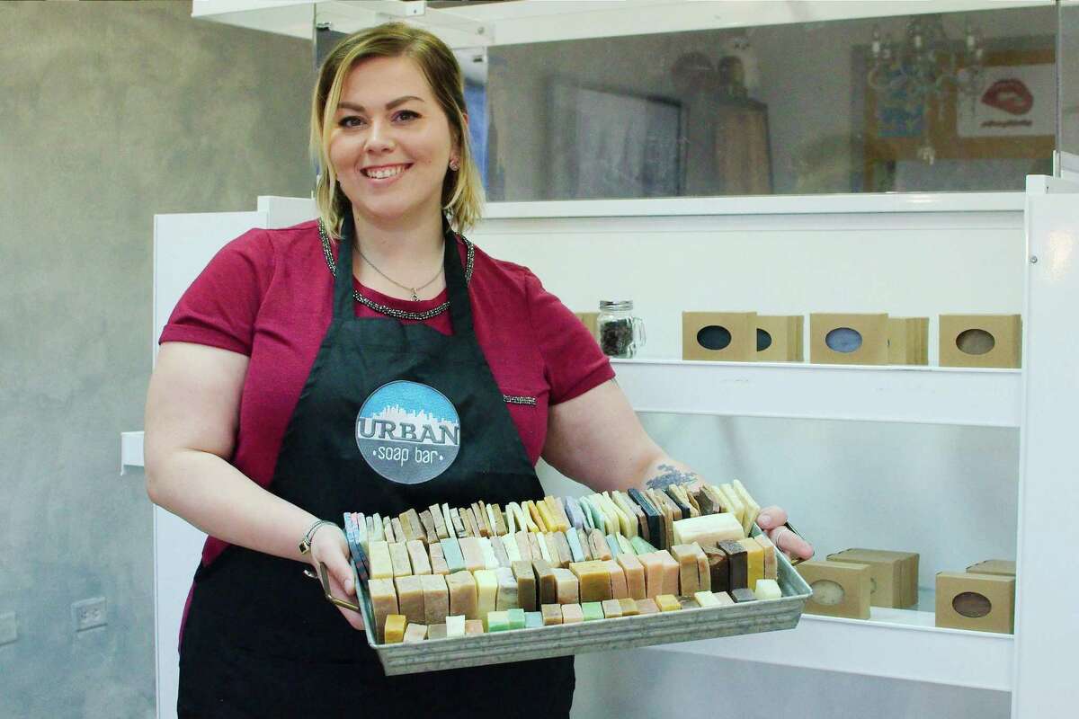 Urban Soap Bar owner Sarah Coligan holds a tray of scented bar soaps in her La Porte store.