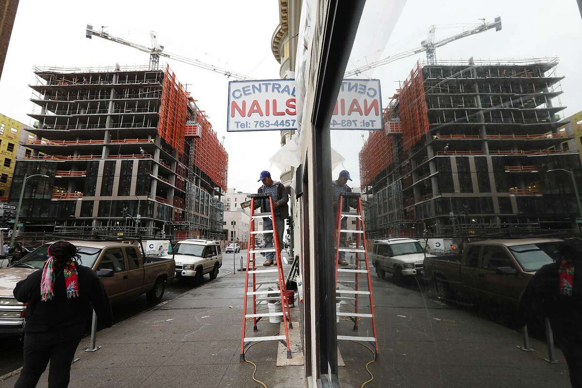A new building is seen under construction on Franklin Street at 14th Street and refelcted in a store front window on Franklin Street on Monday, March 4, 2019 in Oakland, Calif.