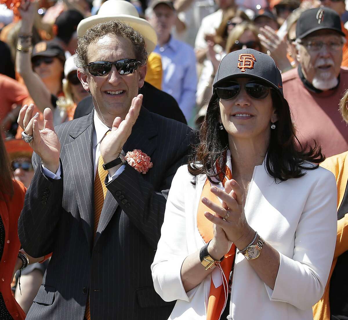 FILE - In this April 8, 2014, file photo, San Francisco Giants president and CEO Larry Baer, and his wife Pam, applaud before an opening day baseball game against the Arizona Diamondbacks, in San Francisco. Baer is taking a leave of absence from the team following the release of a video showing him in a physical altercation with his wife. The Giants board of directors released a statement Monday, March 4, 2019, saying that Baer has been granted a request to take personal time away from the team. (AP Photo/Eric Risberg, File)