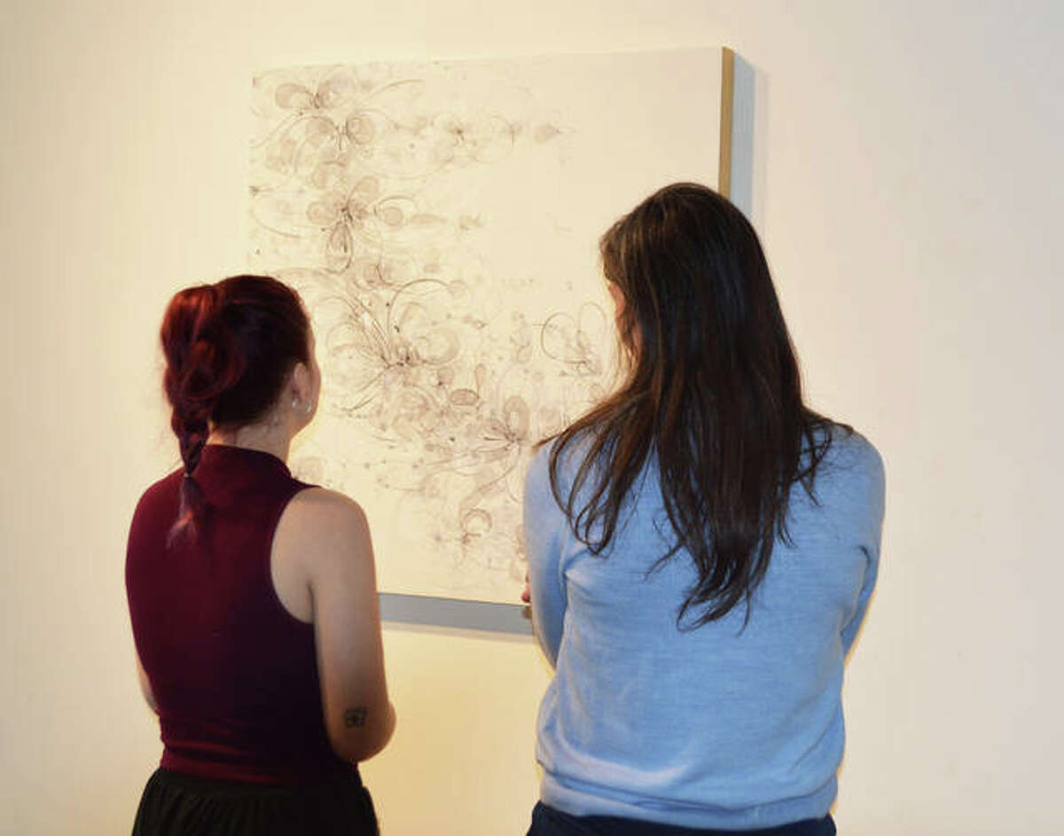 Aurora Robson discusses her painting “Slip Into Something” that was inspired by her dreams, with a student at Principia College.