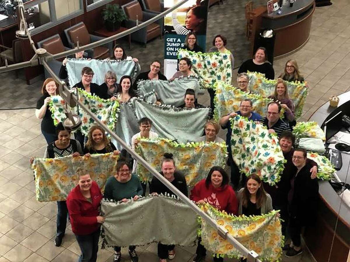 Midwest Members Credit Union employees with the tie fleece blankets they made for newborn babies at Alton Memorial Hospital.