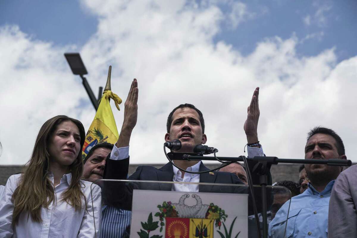 Juan Guaido, president of the National Assembly who swore himself in as the leader of Venezuela, speaks while his wife Fabiana Rosales, left, listens during an opposition rally in Caracas, Venezuela, on Monday, March 4, 2019.