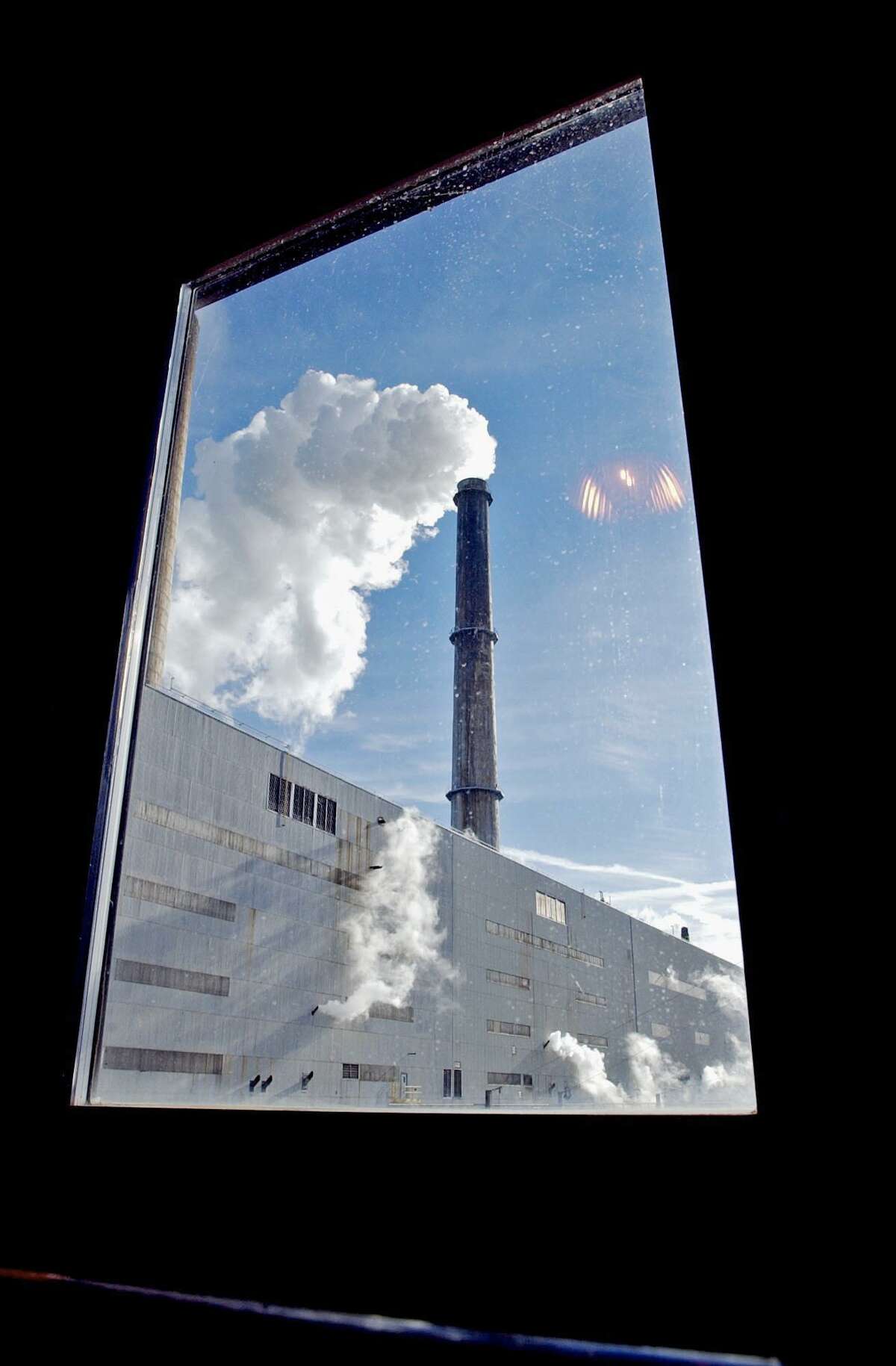 **FILE**The Oak Creek power plant is seen through a window Tuesday, Jan. 13, 2003, in Oak Creek, Wis. in a file photo. The Wisconsin Supreme Court is weighing the future of the $2.15 billion proposed plant in this Milwaukee suburb 80 miles north of Chicago. Its decision could set the standard for whether regulators require energy companies to produce more expensive, low emissions electricity or older, polluting pulverized coal power, according to Bruce Nilles, the Sierra Club's senior Midwest representative. (AP Photo/Journal Times, Gregory Shaver, File) HOUCHRON CAPTION (06/26/2005) SECBIZ COLOR: EXPANSION DESIRED: A smokestack belches at the Oak Creek Power plant in Wisconsin. A $2.15 billion plan to expand the plant outside Milwaukee has angered environmentalists.
