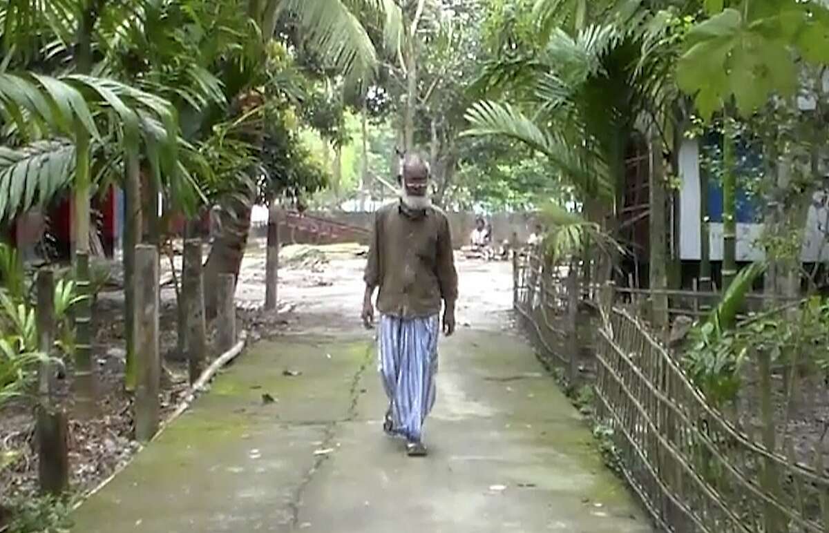 In this image made from video taken Tuesday, March 5, 2019, Ahmed Ali, the father of a British teenager Shamima Begum who ran away to join the Islamic State group in Syria, walks through his village of Sunamganu, 181 kilometers (112 miles) northeast of Dhaka, the capital of Bangladesh. Ali, 60, said his daughter’s citizenship should not be canceled and that she could be punished in the United Kingdom if it was determined she had committed a crime. (AP Photo)