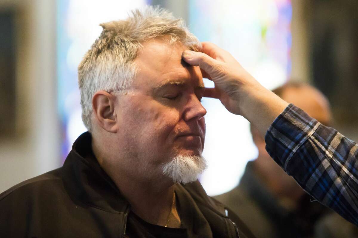 Parishioners receive crosses of ash on their foreheads during an Ash Wednesday service at St. Brigid of Kildare Catholic Church on Wednesday, March 6, 2019. (Katy Kildee/kkildee@mdn.net)