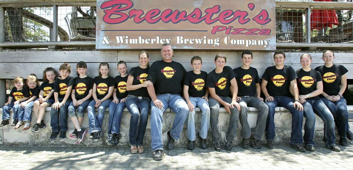 Bruce Collie and family pose at their family business, Brewster's Pizza in Wimberley on June 10, 2011. From left are Dennison, Jadyn, Daltyn, Hansen, Hadyn, Calyn, Bergyn, Holly (mom), Bruce, Cameron, Branson, Denton, Jensen, Jordyn and Devyn. Tom Reel/Staff