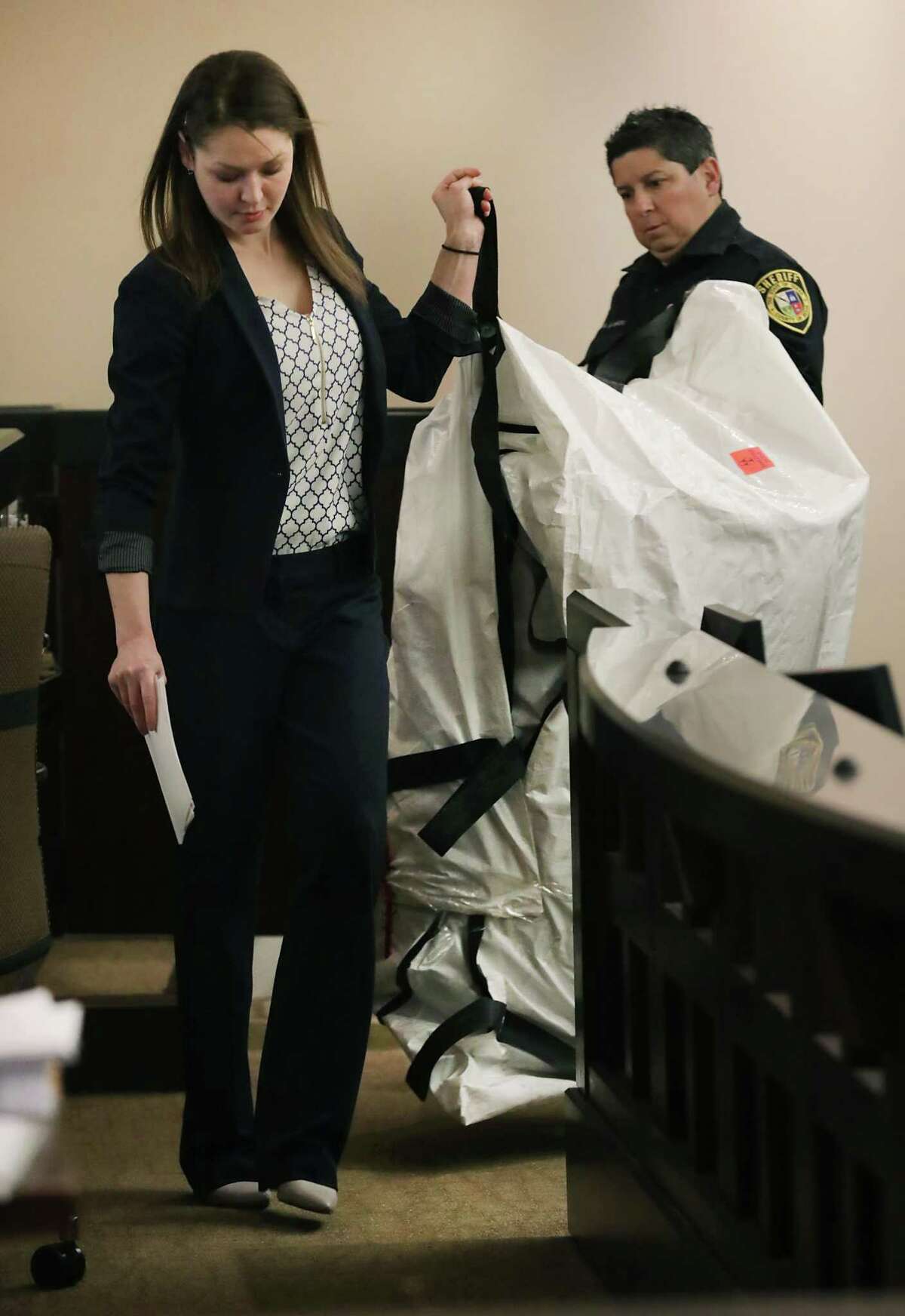 State prosecutor Stephanie Paulissen, left, and a Bexar County Deputy carry a sealed bag containing a barrel that murder victim Joseph Camarrena was stuffed into. Jesse Ray Castilla is on trial for killing Camarena, in the 290th state District Court. The trial started on Wednesday, March 6, 2019.