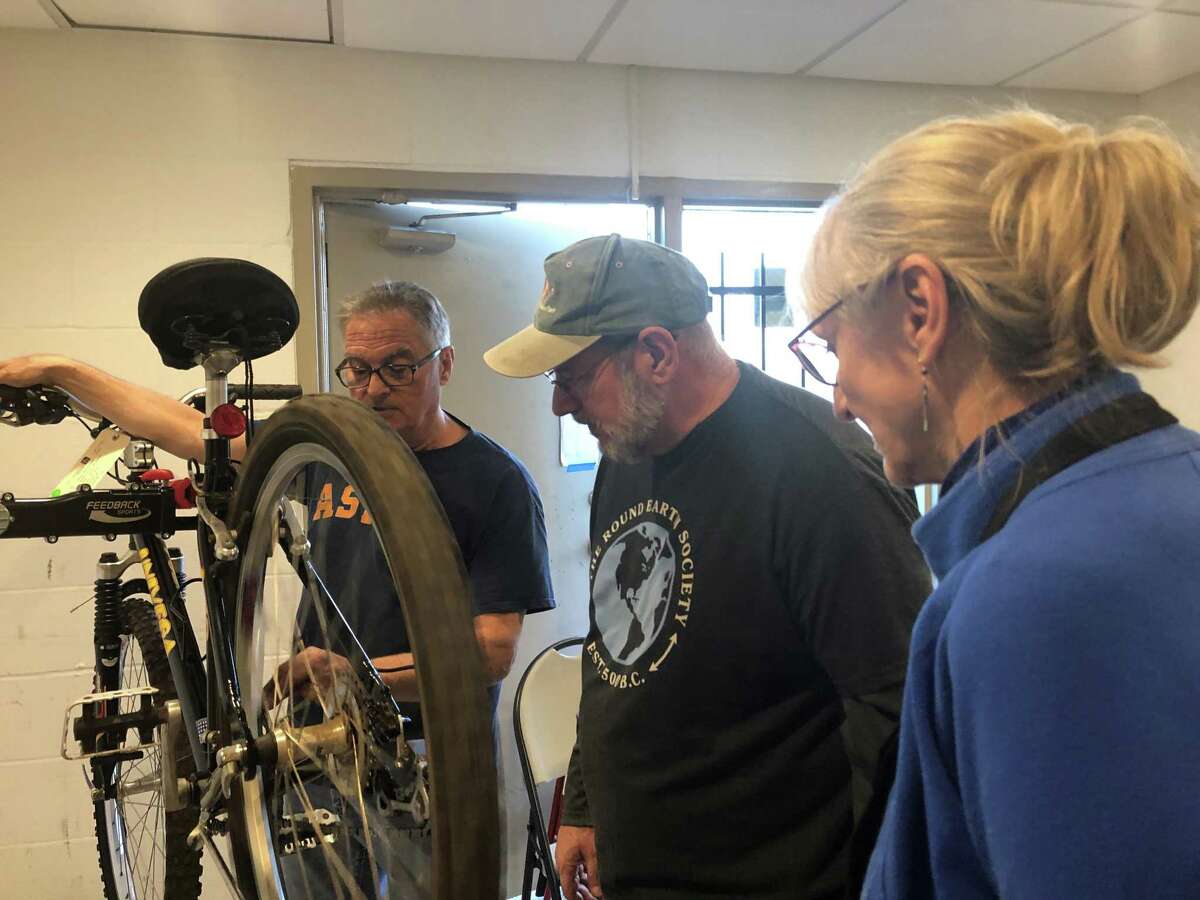 Thom Cope (pictured left) trains Bill Wilkson and Paulette Bogart on how to service a bike at Freewheels Houston. The organization relies on volunteer mechanics to work on bicycles that are then given to refugees, students and veterans coming out of homelessness.
