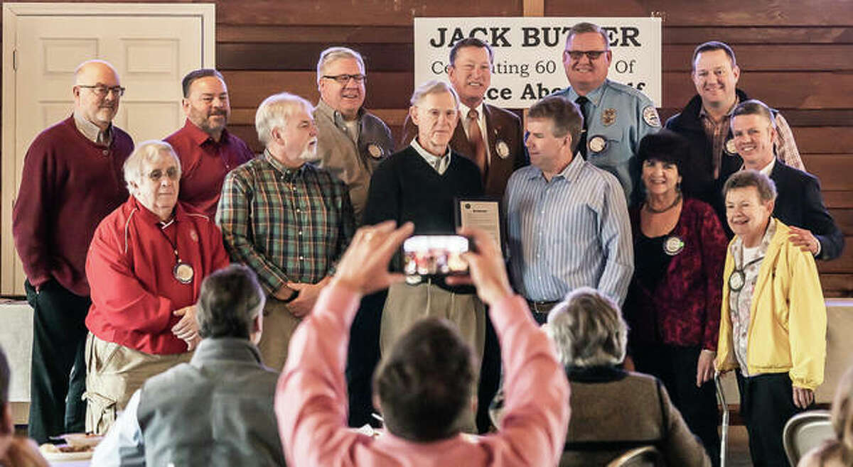 A group of Edwardsville Rotary officers and Edwardsville community service workers and officials surround Jack Butler for a photo Thursday, a request made by Mayor Hal Patton.