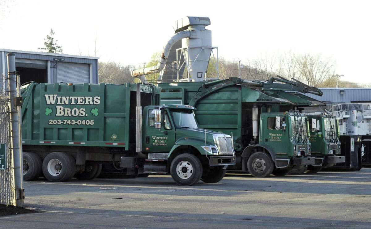 Waste-collection vehicles in downtown Danbury, in a 2014 file photo.