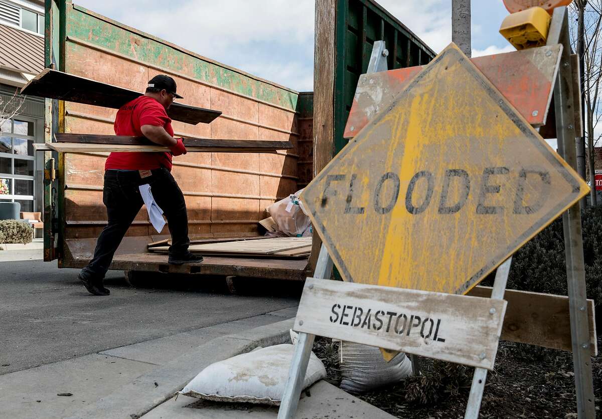 Crews continue to clean up damage caused by floodwaters at The Barlow shopping plaza in Sebastopol, Calif. Friday, March 8, 2019.
