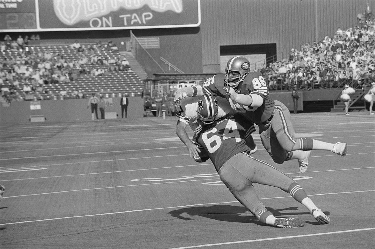 (Original Caption) Atlanta Falcons quarterback Pat Sullivan is caught in a tight squeeze by San Francisco 49ers Cedrick Hardman, (86), and Dave Wilcox in the first period. Sullivan attempted to pass, but could not find his receiver, so elected to run. He made about two yards. The 49ers walloped the Falcons 27-0.